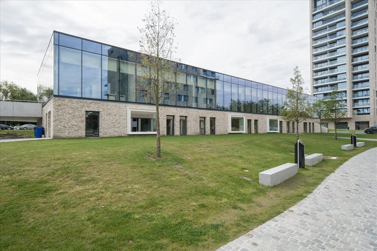 Exterior view of the modern glass-fronted office building at Koning Boudewijnlaan 20A, Hasselt.