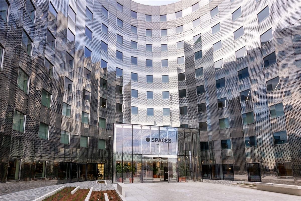 Exterior view of the curved glass facade and modern entrance of Le Belvédère.