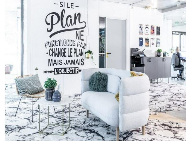Bright reception area at Parc Sud Galaxie with modern white seating and motivational wall graphics.