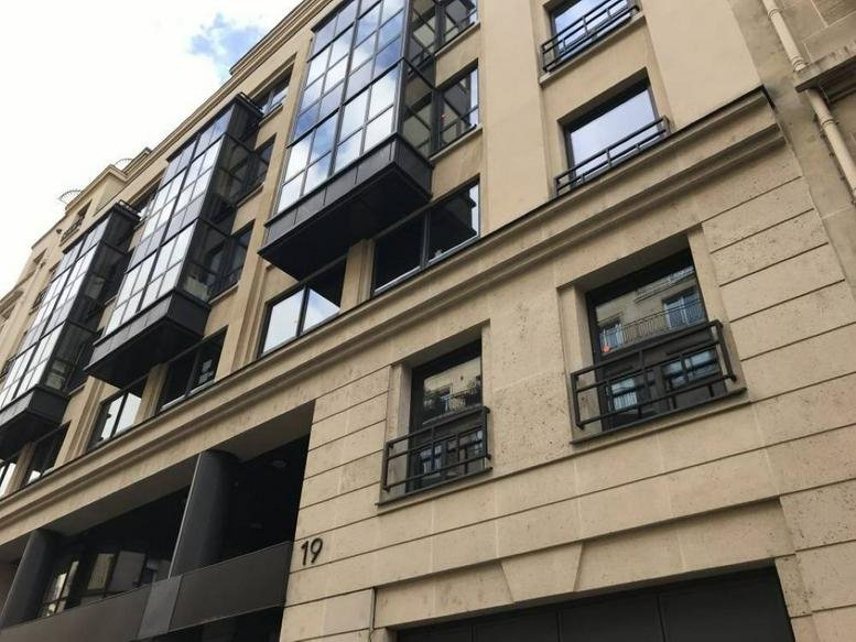 Exterior facade with modern glass balconies at Pont d’Alma, 19 Rue Cognacq-Jay, Paris.