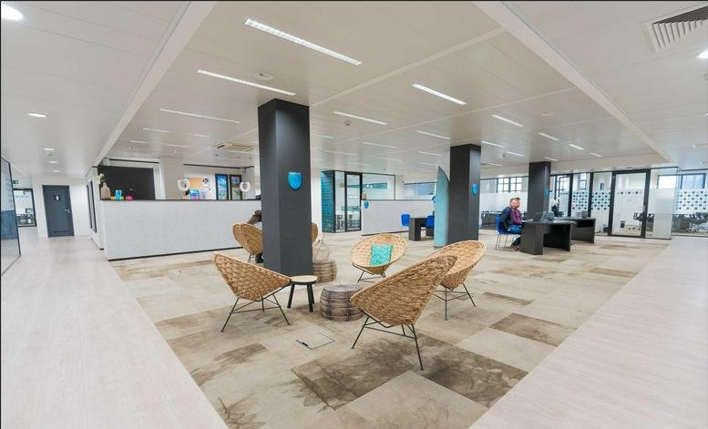 Spacious reception area with wicker chairs and a sleek grey pillar.
