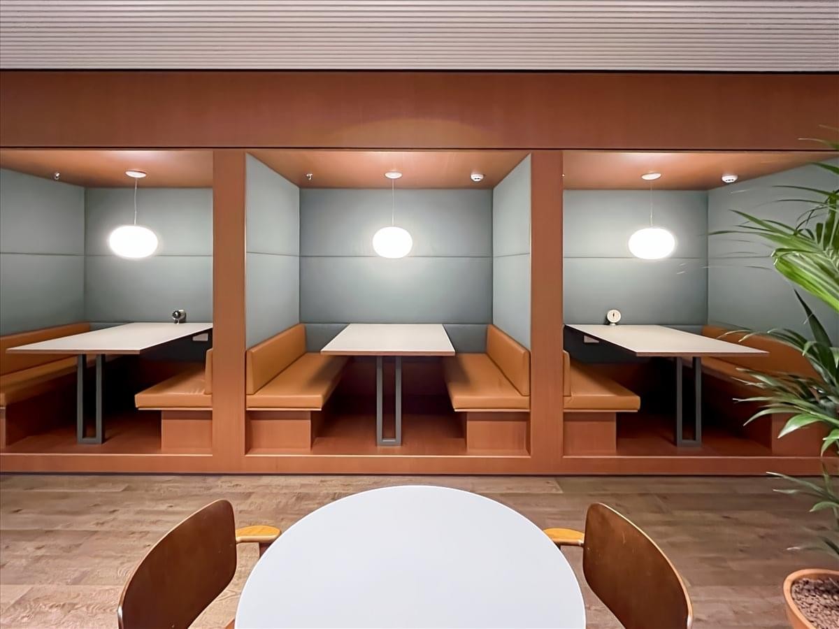 Coworking booths with wooden benches and individual pendant lighting at Sinter-Goedeleplein 14.