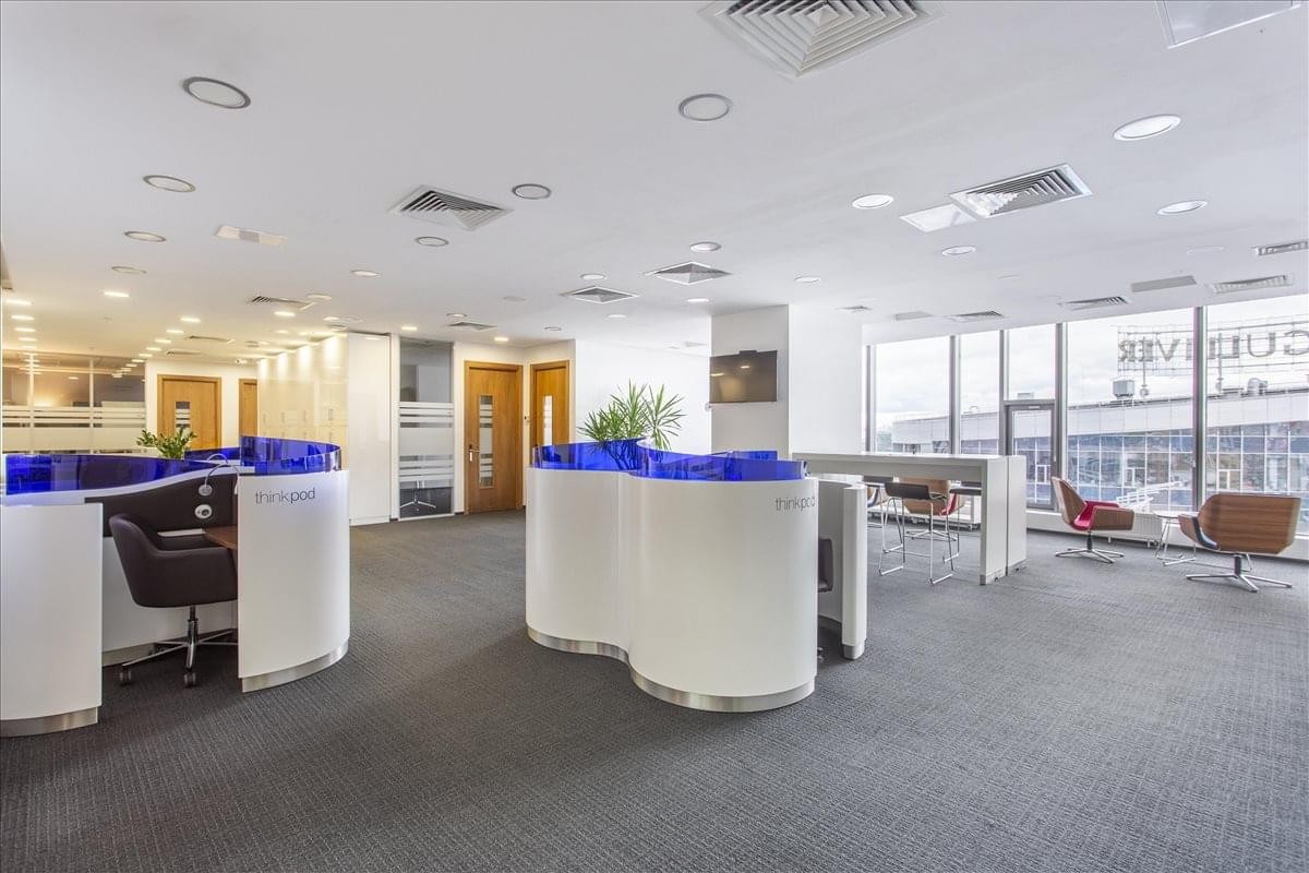 Bright, open-plan reception area with curved white desks and city views.