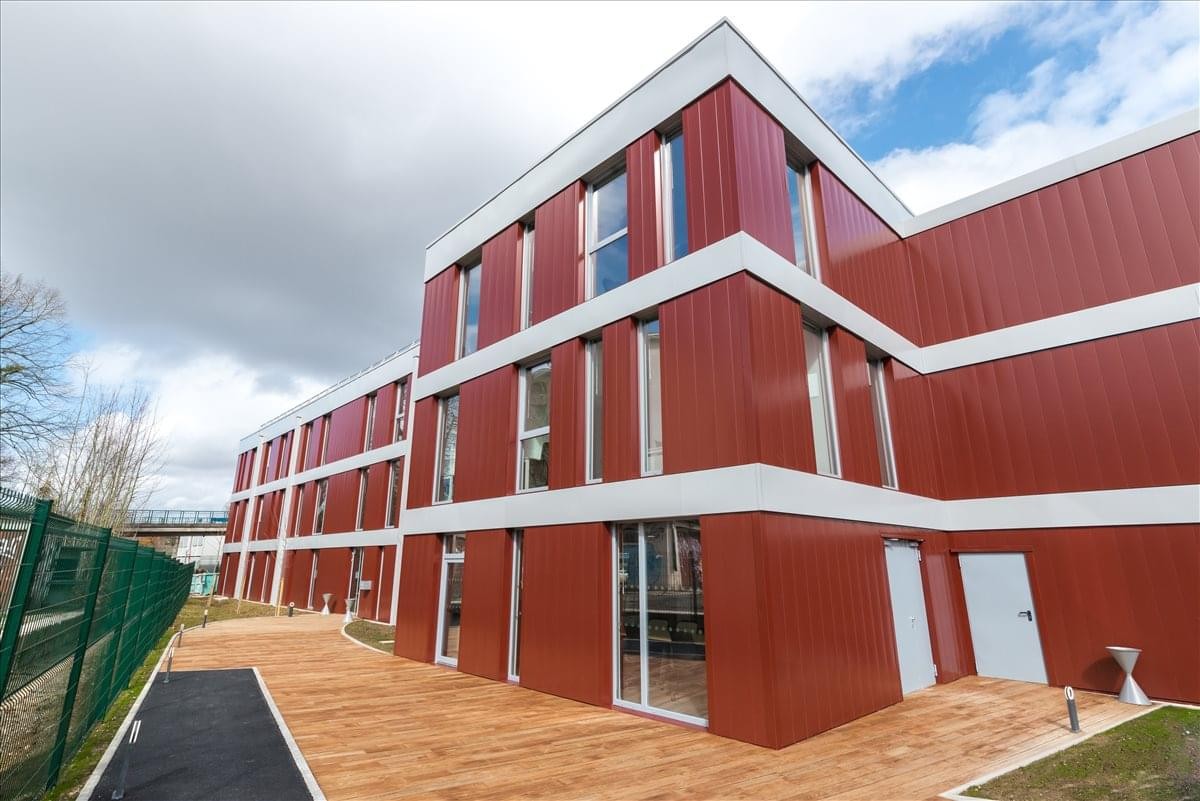 Exterior view of the red and white paneled building at Stop & Work Brunoy.