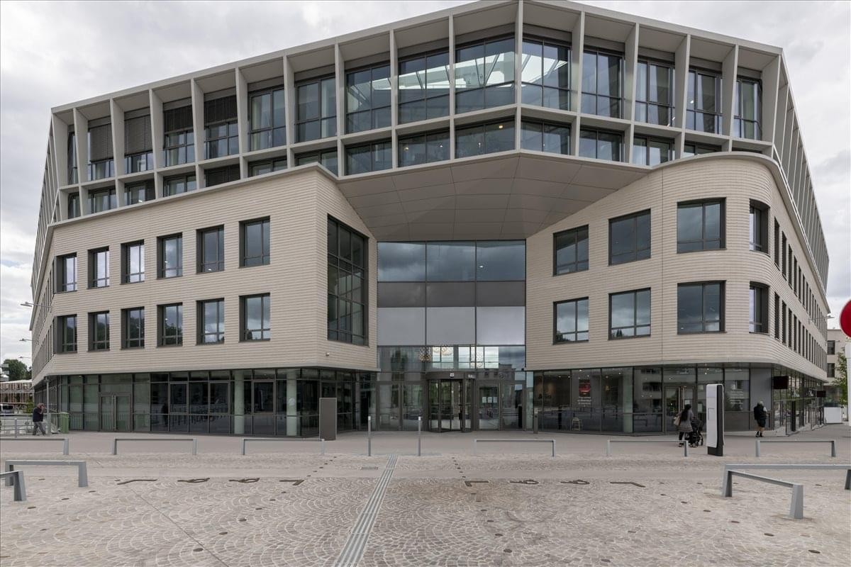 Exterior view of the modern stone and glass Stop & Work, Versailles Chantier building.