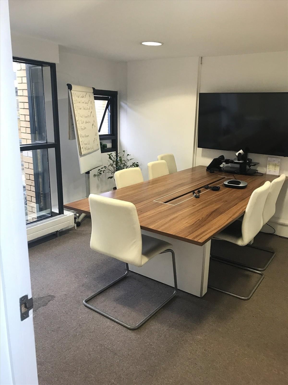 Meeting room at 333 Latimer Road with a large wooden table and white leather chairs.