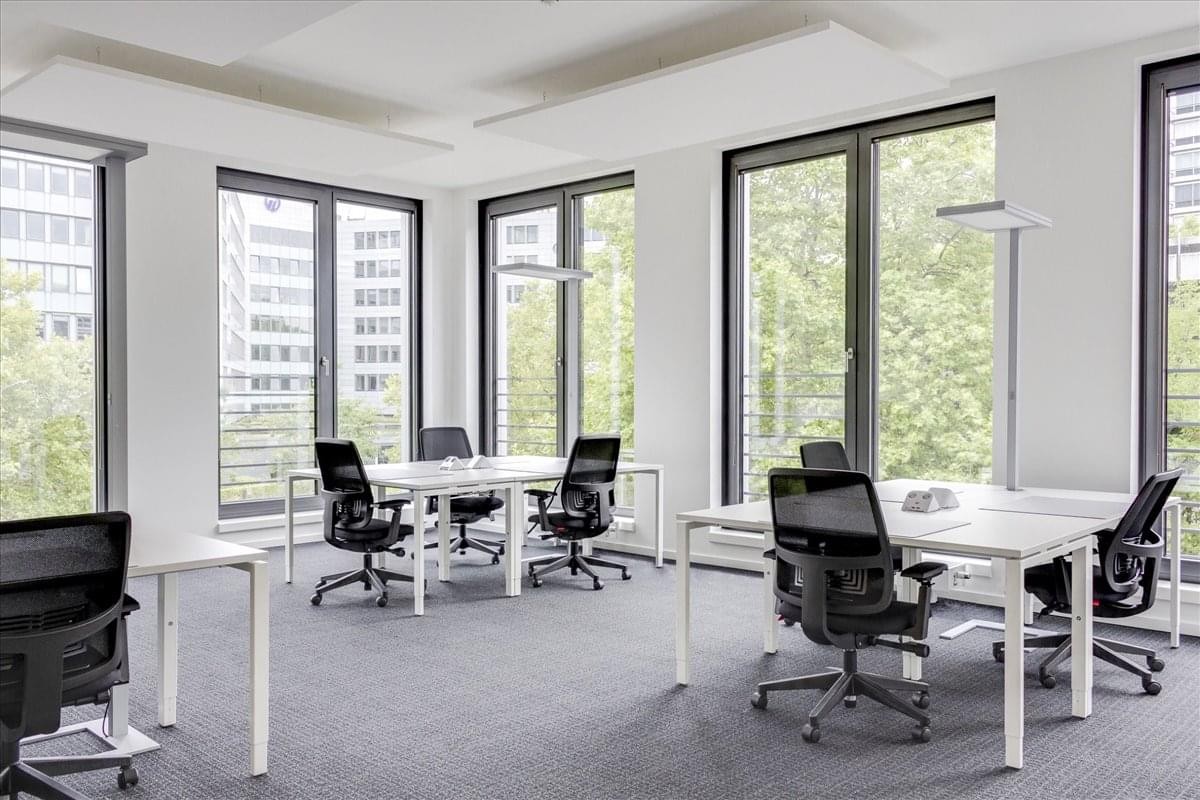 Spacious open-plan workspace at 201 Rue De La Piazza, Noisy-le-Grand, with white desks and large windows.