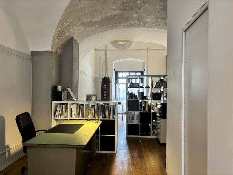 Spacious workspace with vaulted ceilings and wooden floors at Piazza Maravigna.