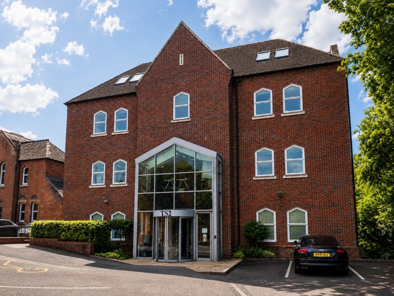 Exterior view of the red brick Pinewood Business Park with its modern glass entrance atrium.