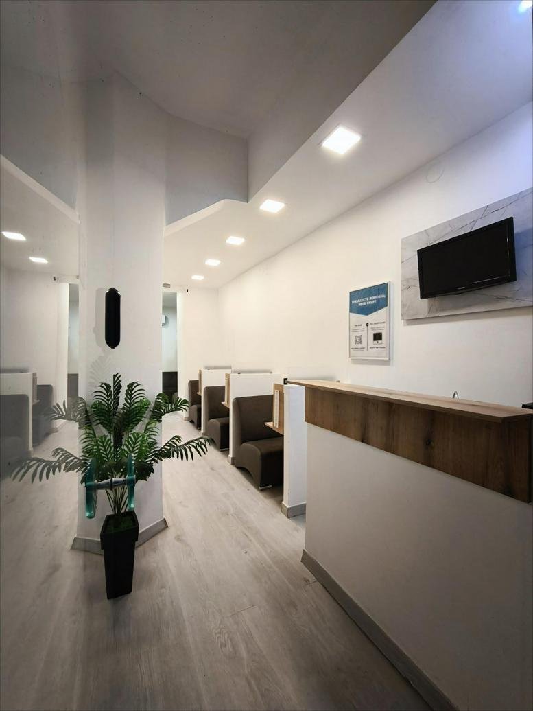 Reception area at Pontou 39, Kalamaria featuring a wooden desk and green plant.