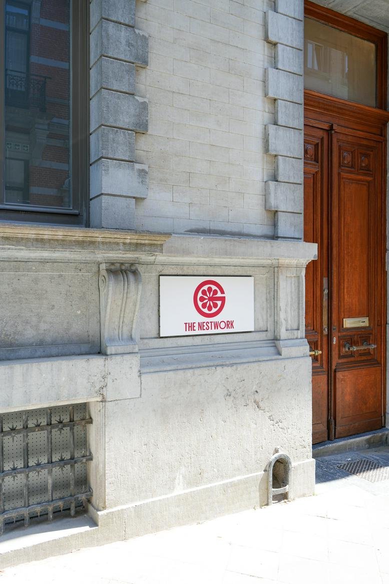Exterior entrance of Rue de la concorde 56 featuring a stone facade and branded signage.