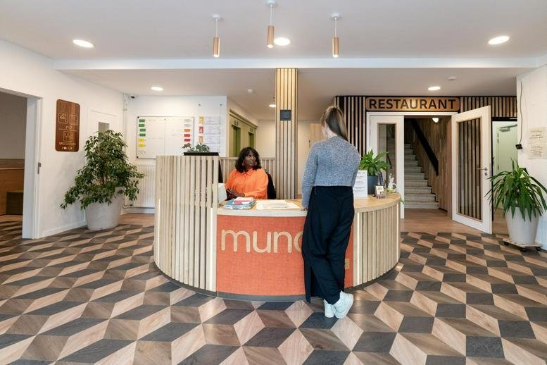 Reception area at Rue Nanon featuring a curved desk and patterned floor.