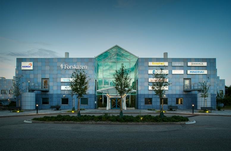 Exterior view of the Scheelevägen 22 building with its unique blue glass facade and central entrance.