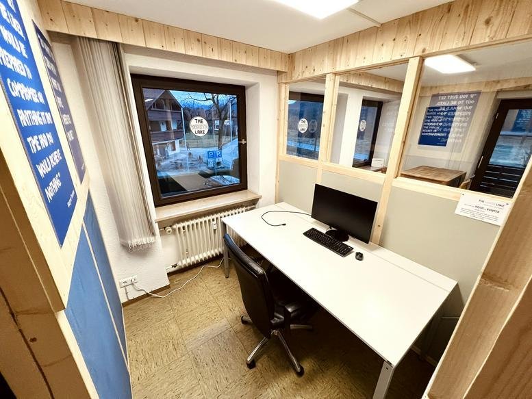 Compact private office at Seeweg 4 featuring a white desk, monitor, and window with natural light.