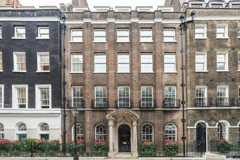 Grand historic brick facade of 1-3 Frederick’s Place with arched entrance and black railings.