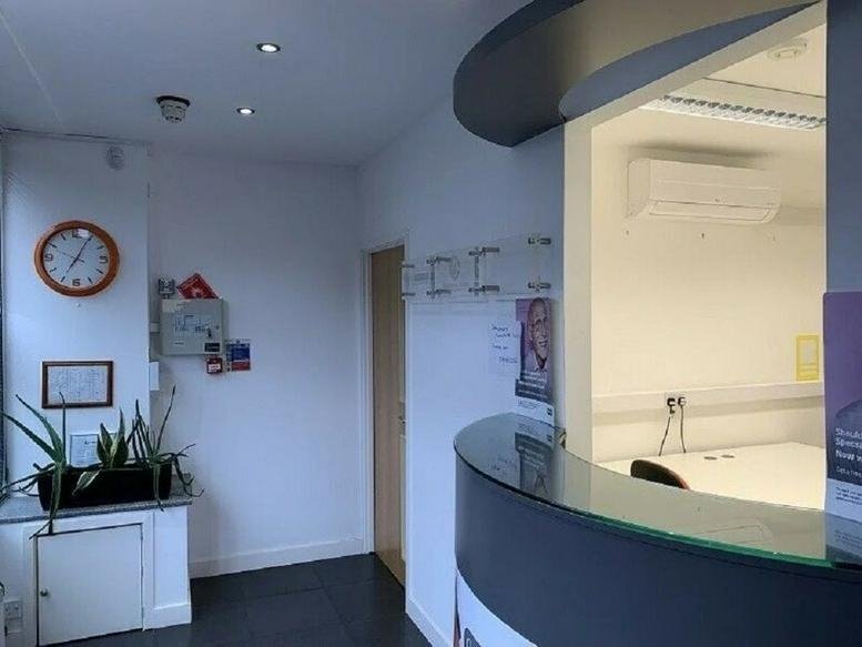 Reception area at 1-3 St Mary's Avenue featuring a curved desk and wall clock.