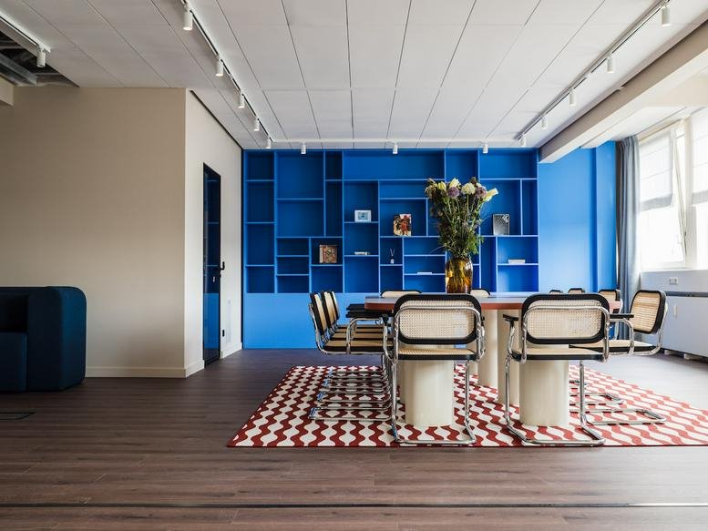 Meeting area at 1 Alexanderstraße, Alexanderplatz featuring a vibrant blue wall and patterned rug.
