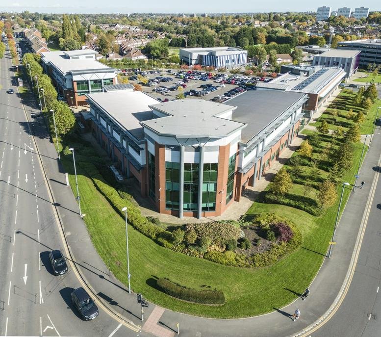 High-angle aerial view of the red brick and glass building at 1 Devon Way, Birmingham.
