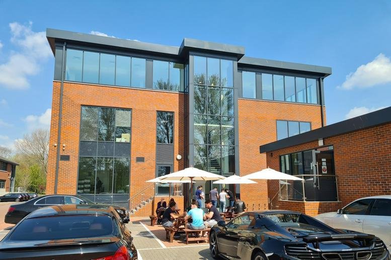 Exterior view of the brick and glass office building at 1 Meadlake Place, Egham.