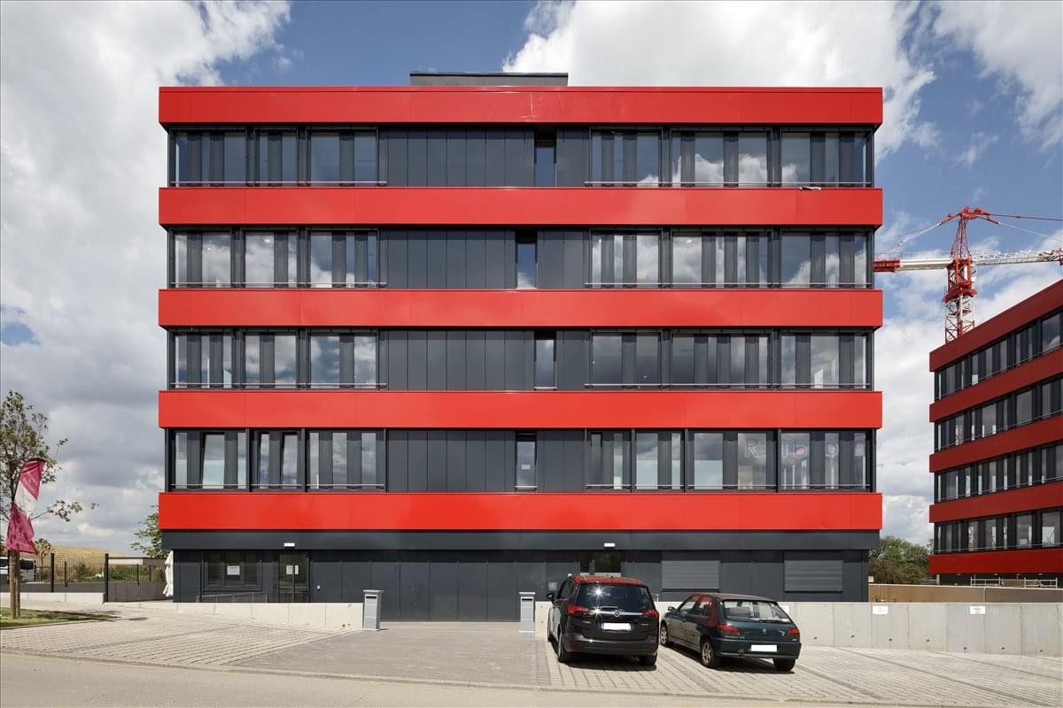 Exterior view of the modern red and black striped building at 1 rue de Turi, Roeser, Livange.