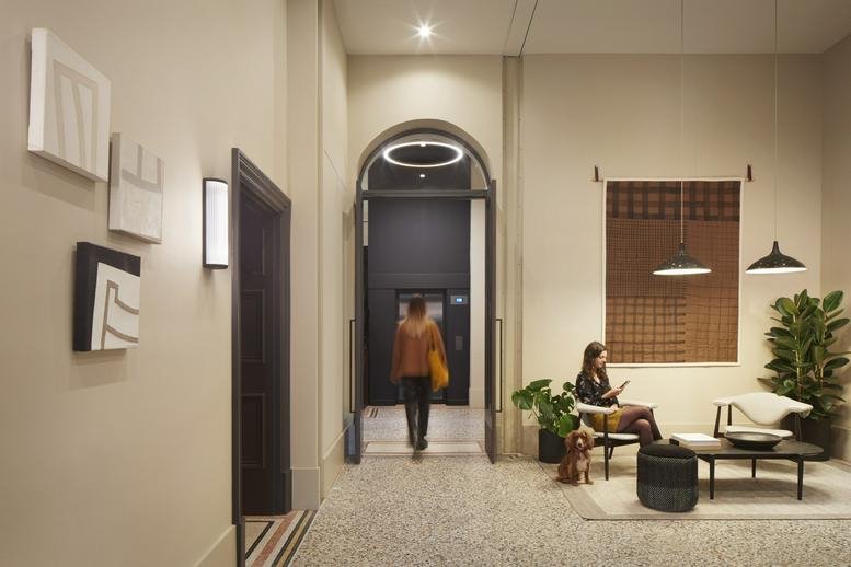 Reception area with arched doorway, minimalist artwork, and comfortable lounge seating.