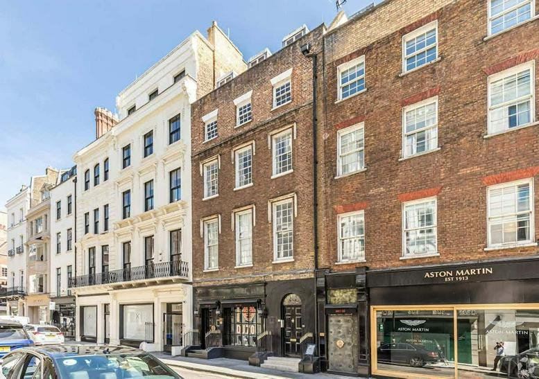 Classic brick and white stone facade of the multi-story building at 10, Dover Street, London.