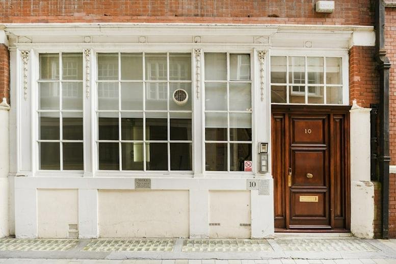 Exterior view of the classic brick facade and dark wood entrance at 10 Ironmonger Lane.