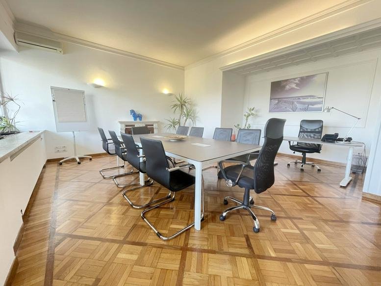 Spacious sunlit boardroom at 10, Viale Belfiore, Florence (Firenze) with polished parquet and white walls.
