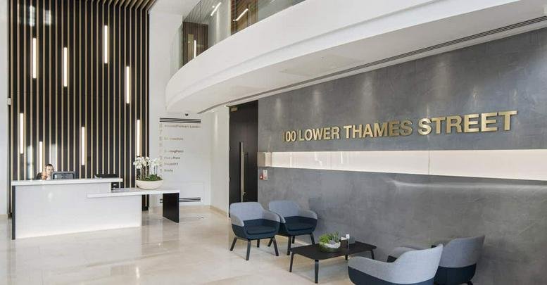 Modern lobby at 100, Lower Thames Street featuring a sleek reception desk and comfortable lounge seating.