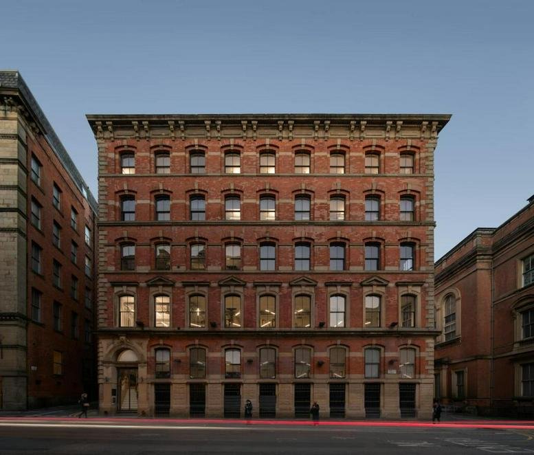 Grand red brick exterior facade of 101 Princess Street, Manchester with arched windows.