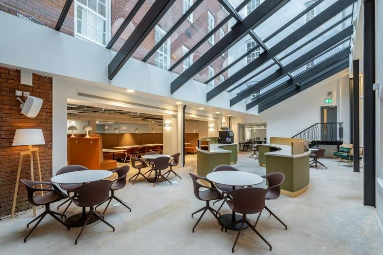 Spacious communal atrium at 102 Colmore Row with glass ceiling and modern seating areas.