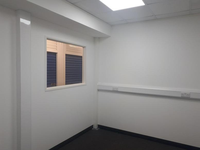Bright private office at 105 Oyster Lane, West Byfleet with a viewing window and wall-mounted power trunking.