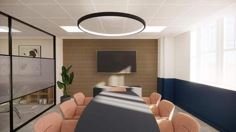 Meeting room with a large round pendant light, wood-paneled wall, and salmon-colored chairs.