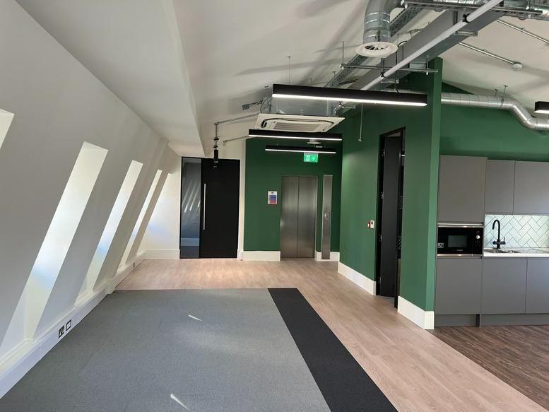 Spacious communal area at 107 Gray’s Inn Road with a modern kitchen, green feature walls and vaulted ceilings.