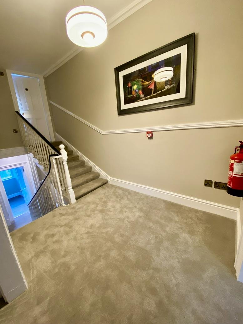 Common area landing at 107 Lower Baggot Street with stairs, carpeted floors, and a framed artwork.