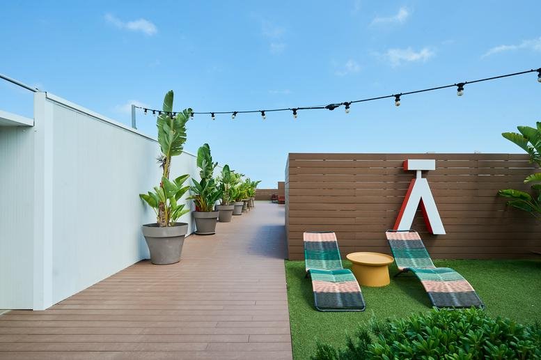 Sunny rooftop terrace with wood decking and lounge chairs at 108, Carrer de Pallars.