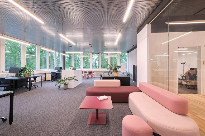 Spacious communal lounge at 11, Neuhofstrasse, Reinach with pink sofas and a red coffee table.