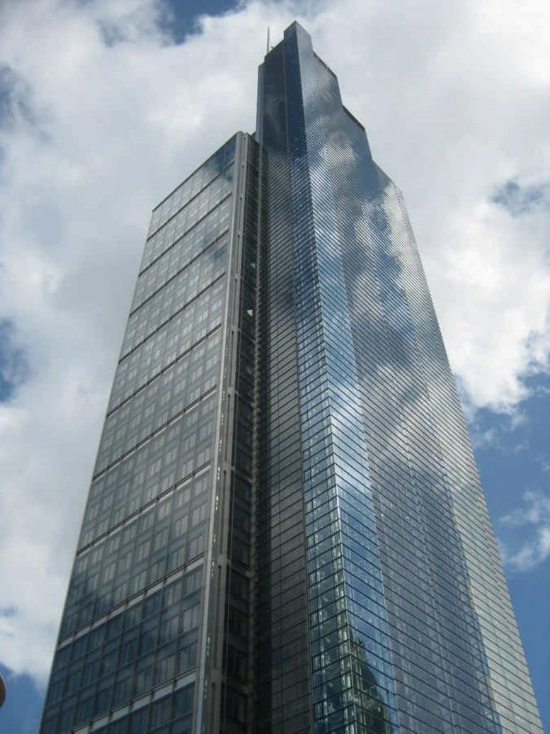 Low-angle exterior view of the glass skyscraper at 110 Bishopsgate, London reflecting the clouds.