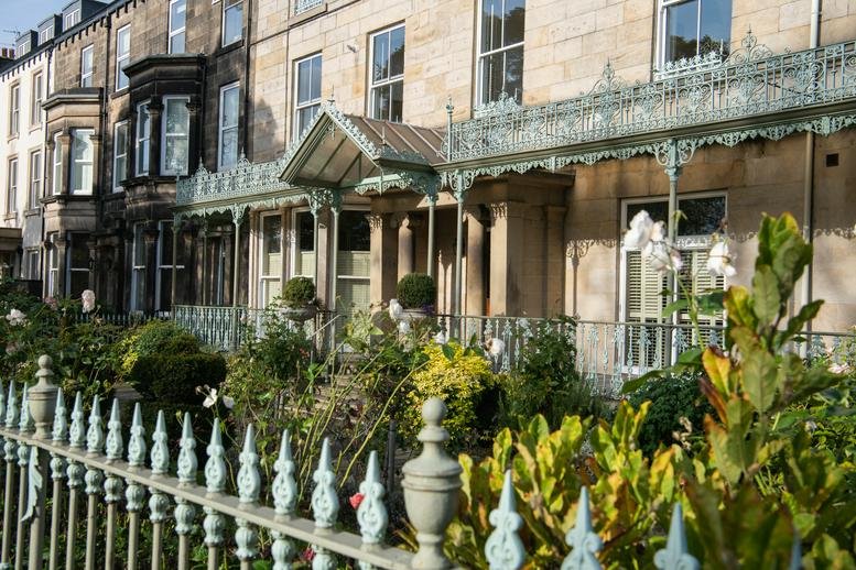 Stone exterior of 110 Station Parade, Royal House, featuring ornate wrought iron detailing.