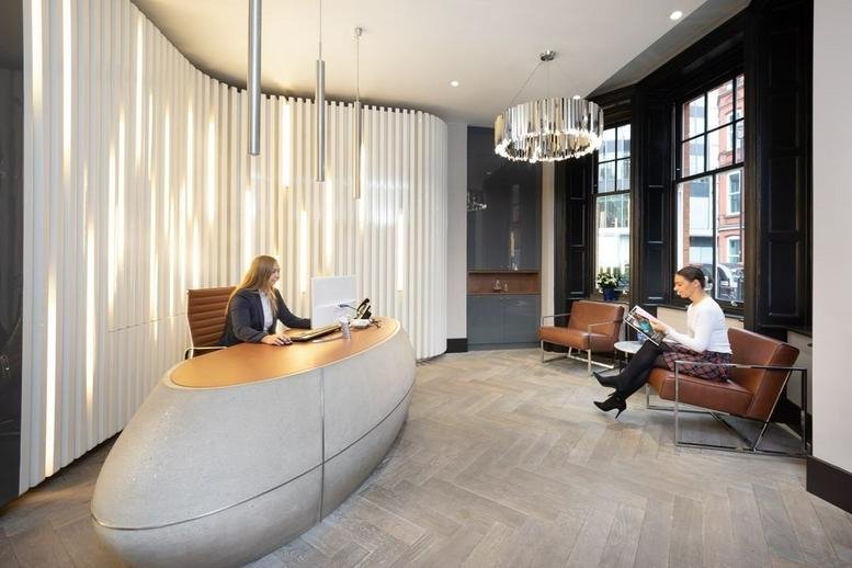 Modern reception area at Park Street Office Space - Mayfair, Westminster with a curved desk and feature lighting.