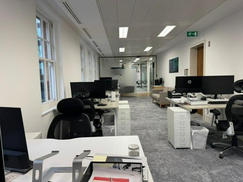 Spacious open-plan workspace at 115, Park Street, London featuring rows of desks and large windows.
