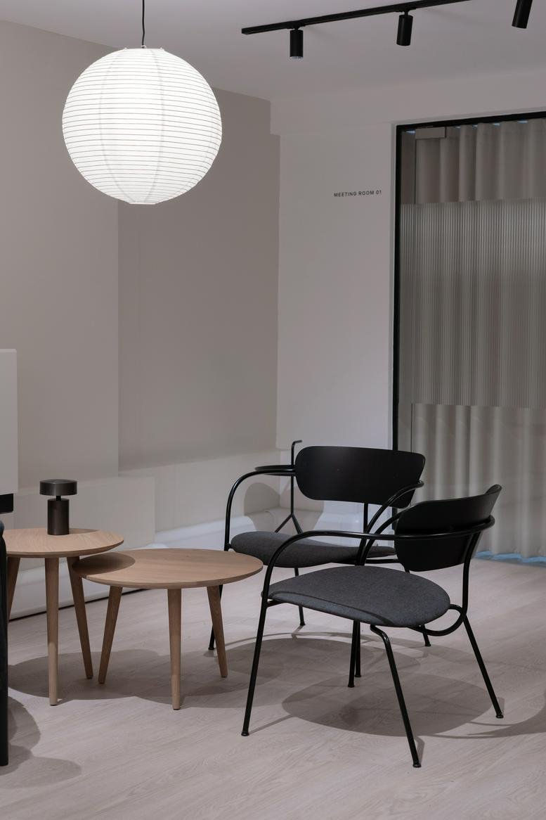 Modern lounge area with round paper lantern and designer chairs.