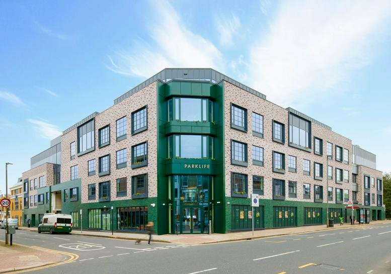 Exterior corner view of the 116 Putney Bridge Road, Parklife building featuring green and brick facade.