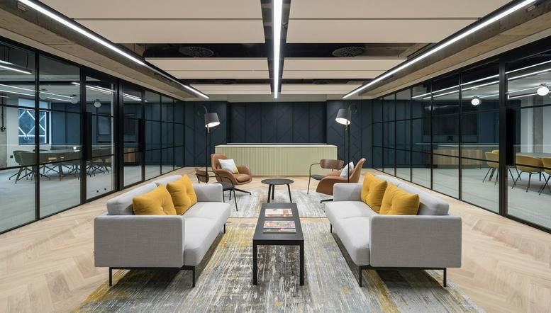 Spacious reception lounge at 119-121 Cannon Street, Yarnwicke with grey sofas and yellow pillows.