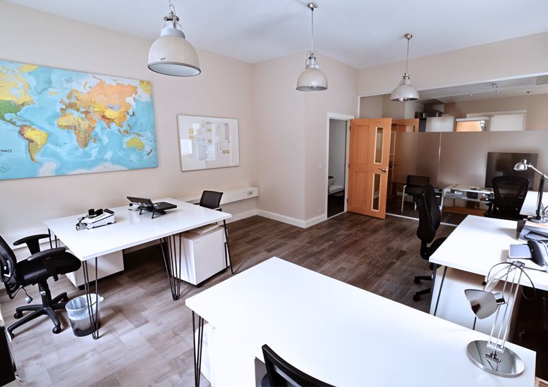 Spacious office suite featuring a large world map wall mural and hardwood flooring.