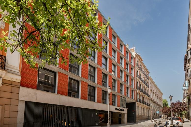Exterior view of the orange and grey facade of 12, Calle de Prim, Madrid.