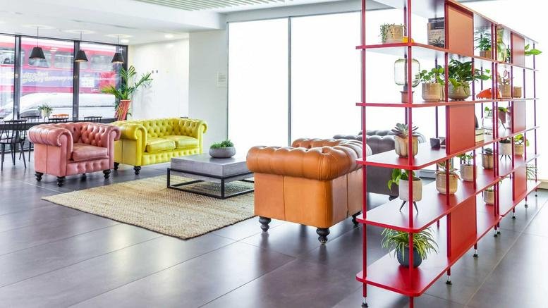 Colorful breakout area at 120 Aldersgate Street with tufted leather sofas in pink, yellow, and tan.