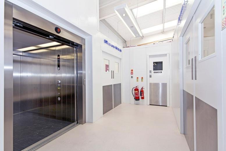 Bright modern reception area at 1250 High Road, Central London, featuring a sleek elevator and white walls.