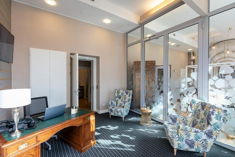 Elegant executive desk and guest armchairs in a suite at 13-15 avenue de la Liberté.