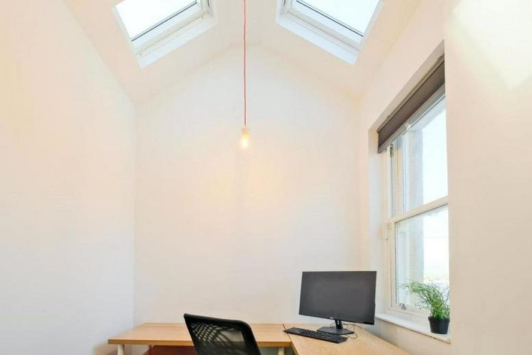 Bright workspace at 13 New Market Street, Colne, England with high vaulted ceilings and skylights.